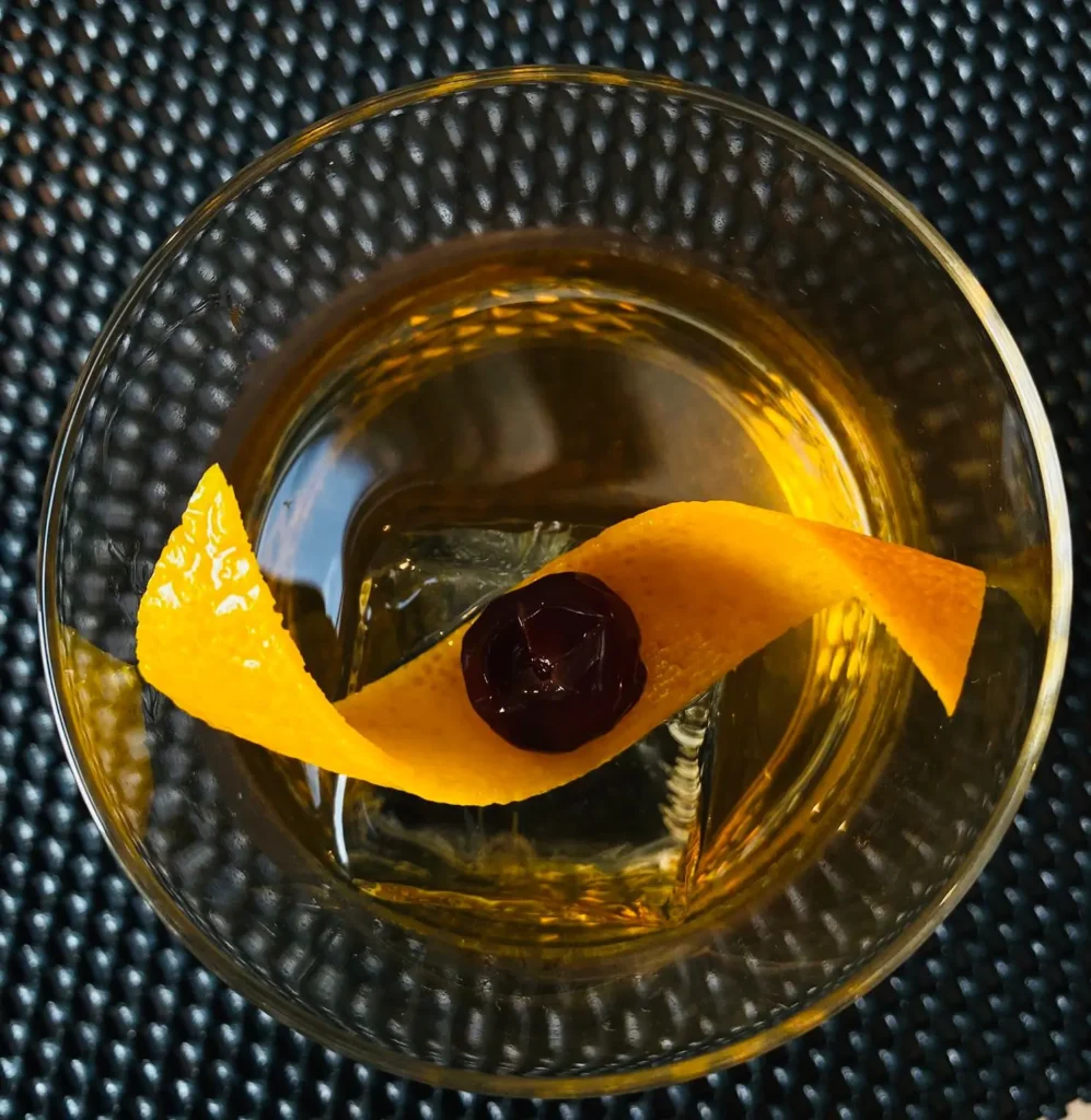 The old fashioned van boven. Zie de sinaasappelschil en kers elegant rusten op het ijs.